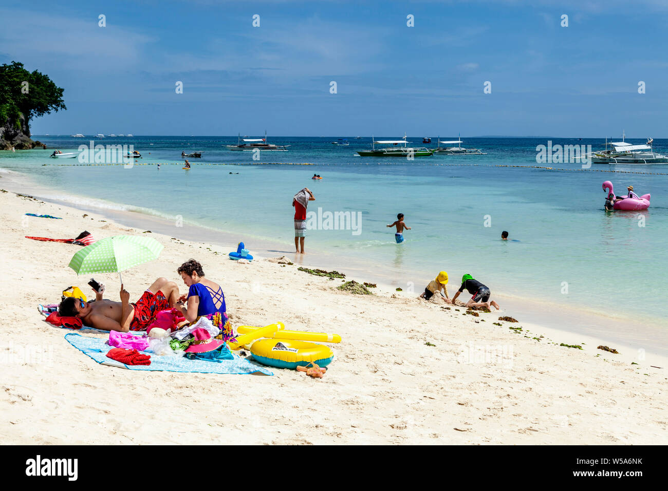 A Family Relaxing On Alona Beach, Bohol, The Philippines Stock Photo