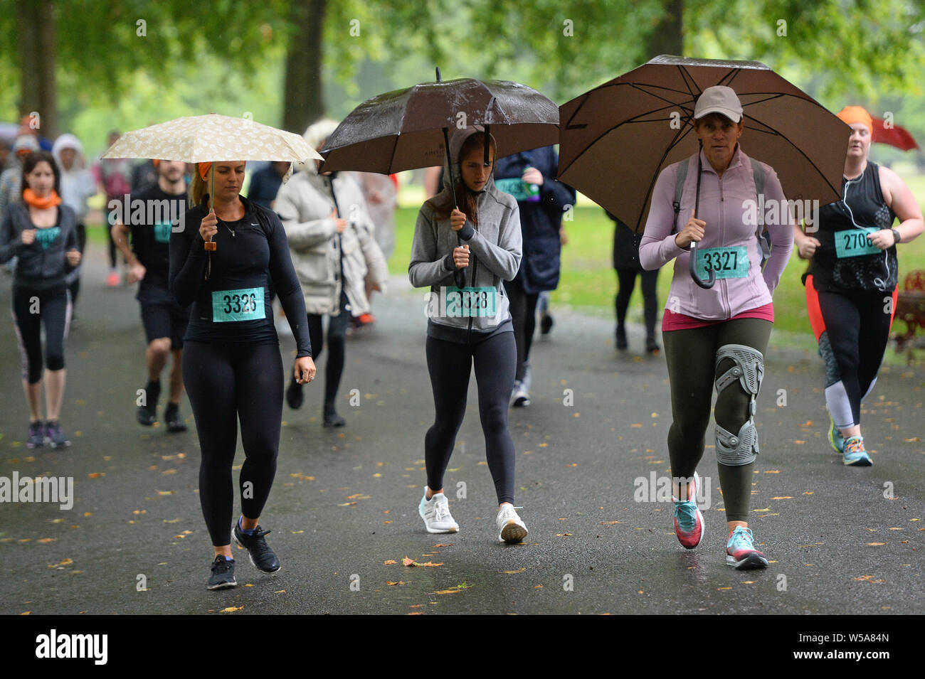 Women Takes Part In A Run Whilst Holding Umbrellas In Battersea Park London Stock Photo Alamy Women Takes Part In A Run Whilst Holding Umbrellas In Battersea Park London Stock Photo Alamy