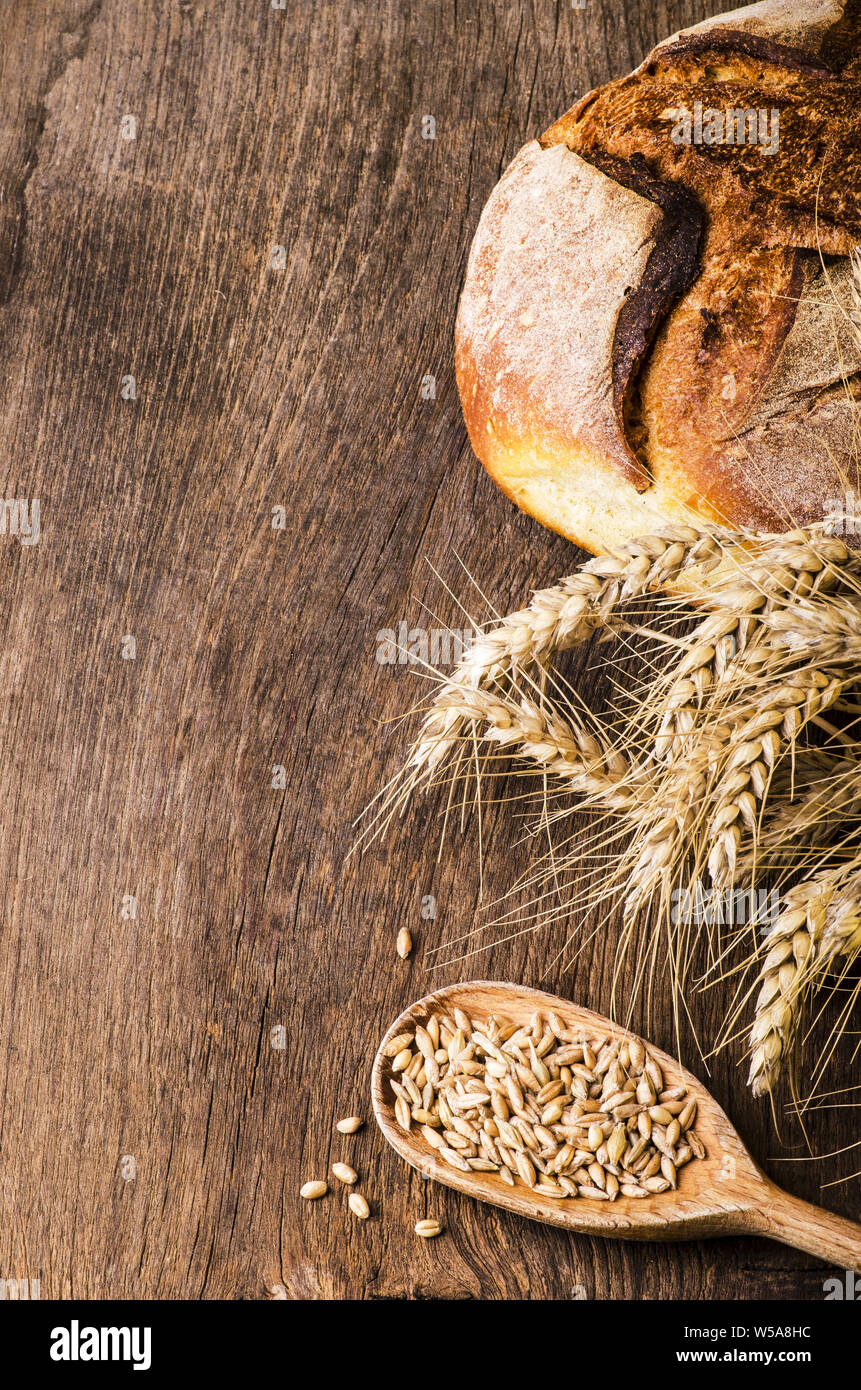on the rustic wooden table a loaf of bread, flour in a jute sack and ...