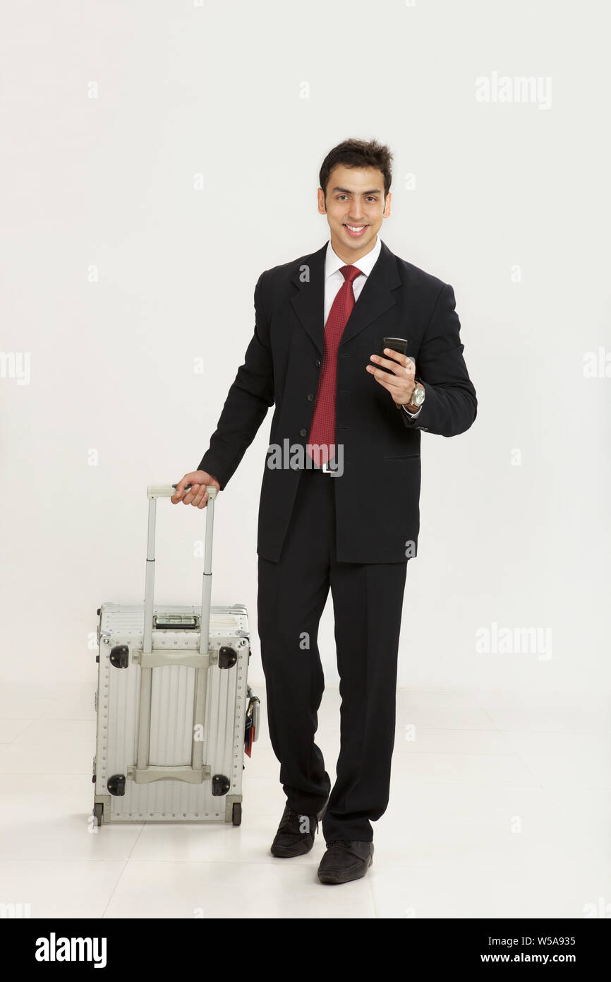Businessman text messaging and smiling Stock Photo
