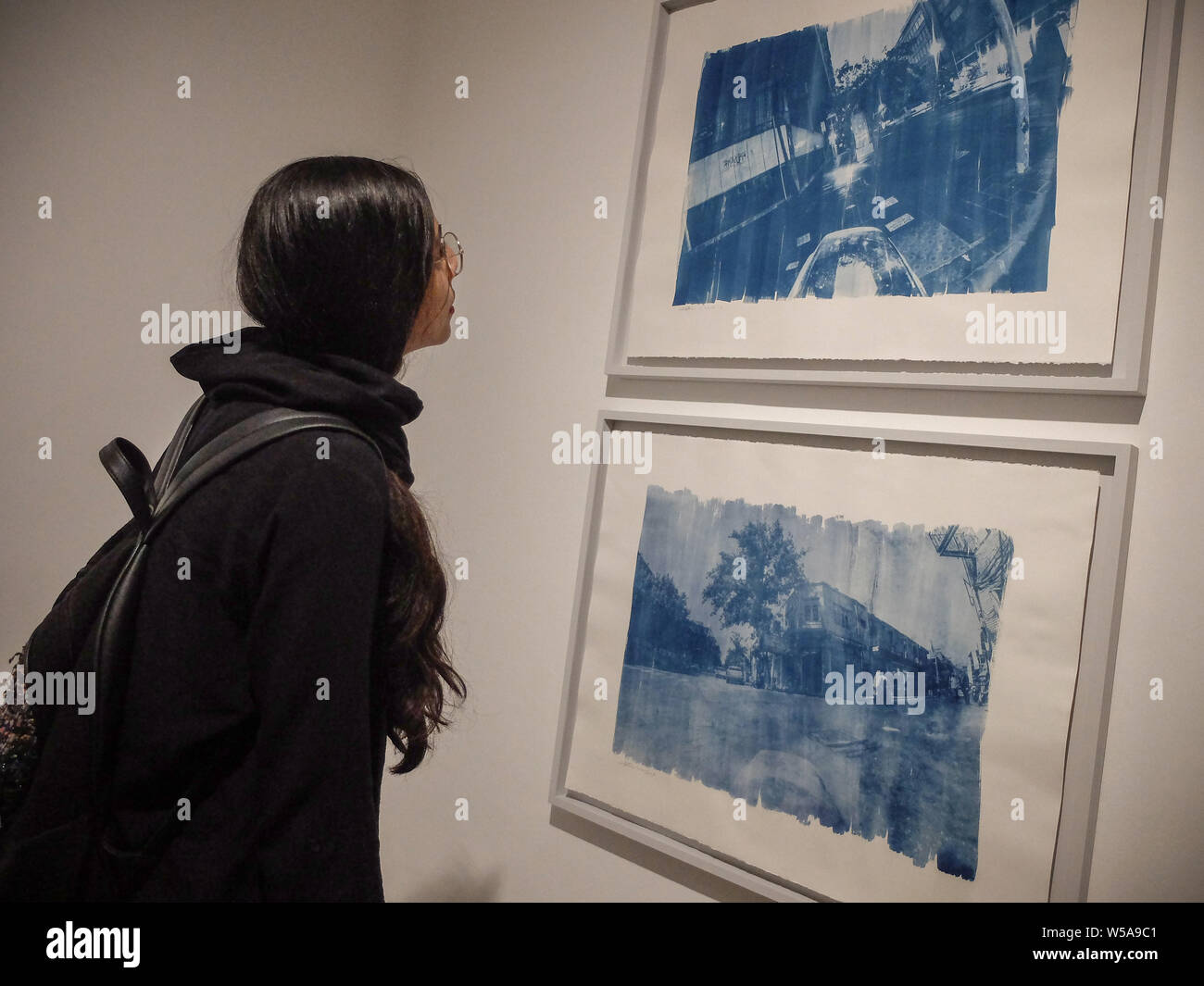 July 26, 2019, Tehran, Tehran, IRAN: People visit Vahid Dashtyari and Mehdi Khandan's photo exhibition at Mohsen Gallery in downtown Tehran, Iran. The two-man photo show by Vahid Dashtyari and Mehdi Khandan is about alternative photographic processes, namely gelatin silver, and cyanotype, to record reality: One is seeking to recover the lost spirit of photography and revert something fake to its original form, while the other is searching for the lost soul of the city, changing something authentic to a counterfeit. Credit: Rouzbeh Fouladi/ZUMA Wire/Alamy Live News Stock Photo