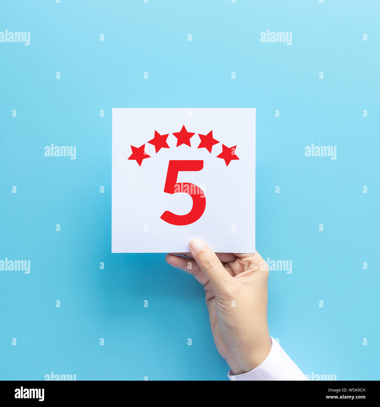 rating and feedback concept. customer holding paper with satisfied review by give five star for service experience Stock Photo