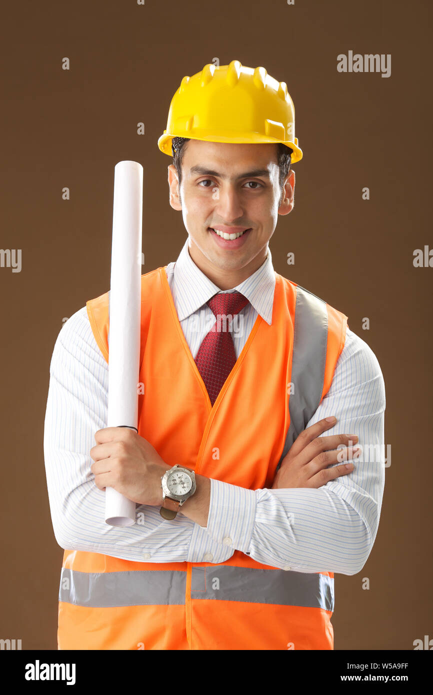 Male architect holding a blueprint and smiling Stock Photo