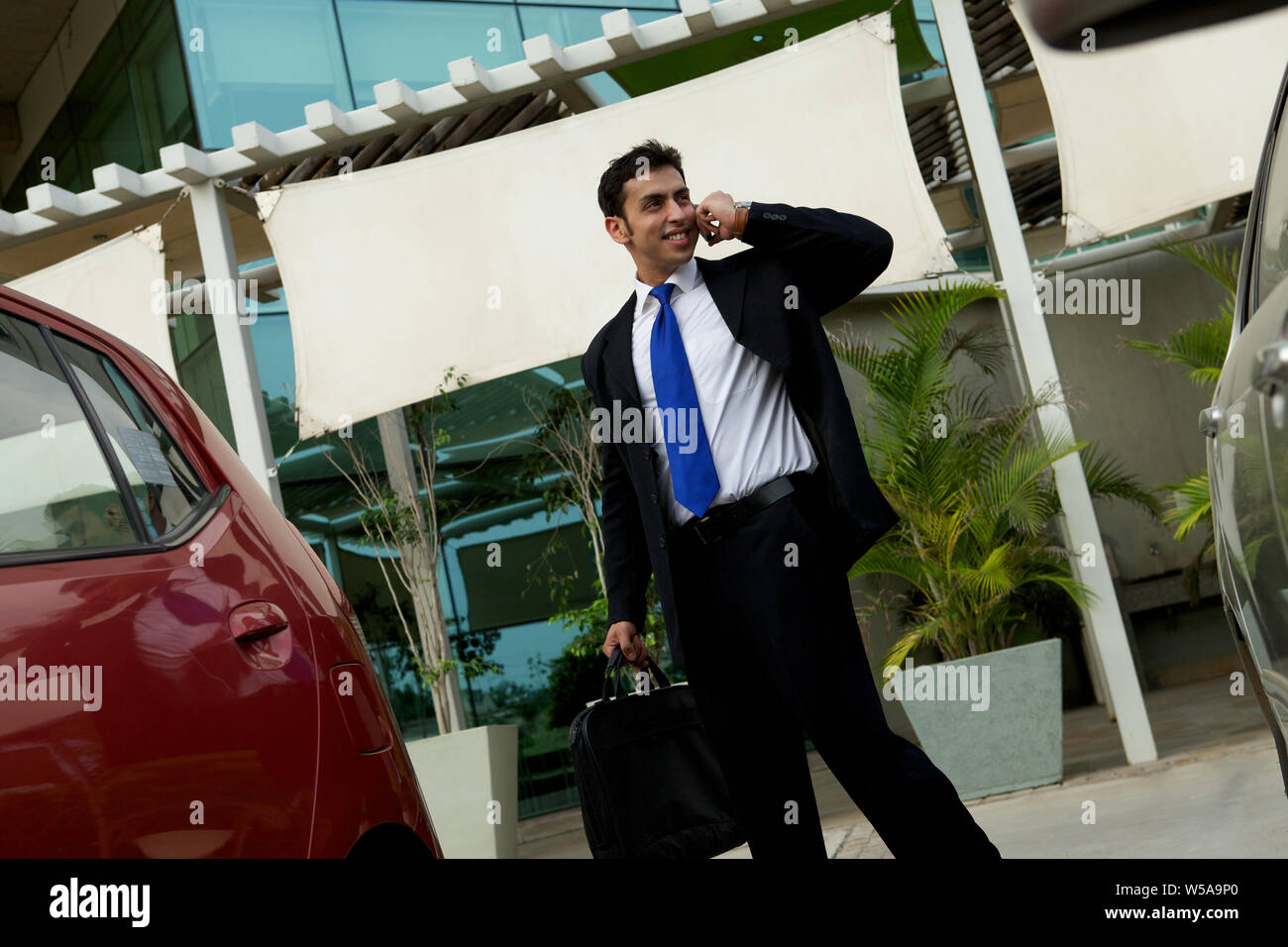 Businessman talking on mobile phone with bag Stock Photo