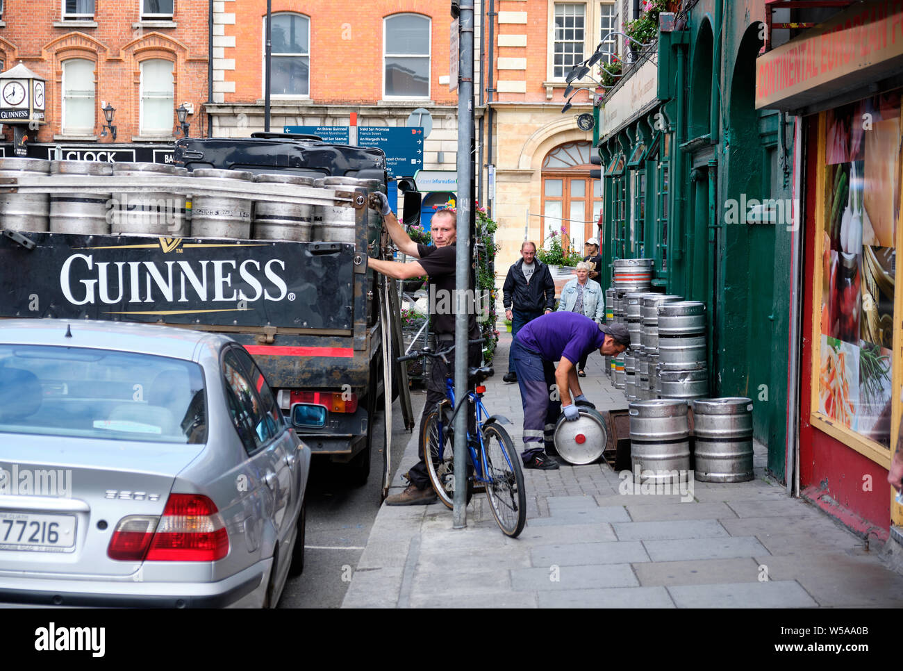 Guinness beer delivery to pub in Dublin. Man unload truck of barrels