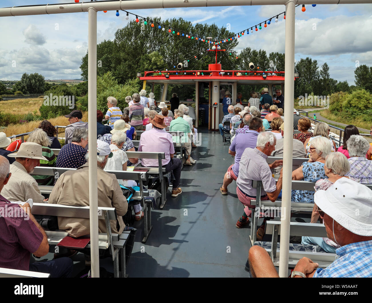 Passengers enjoying the sunshine, views and conversation on an Exeter Canal Cruise, up Europe’s oldest working ship canal. Stuart Lines Cruises Stock Photo