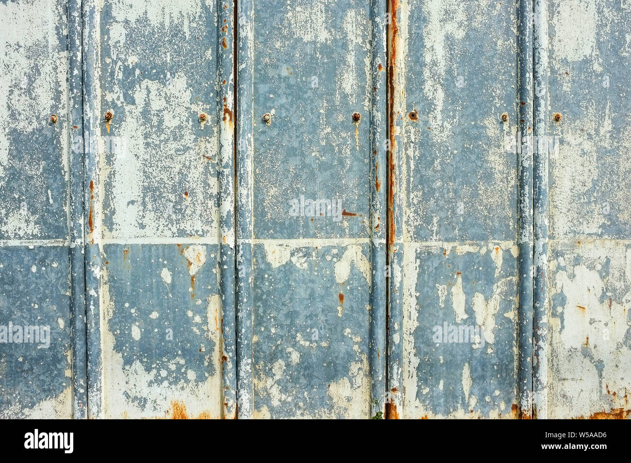 Cracked paint peeling on a metal fence. Stock Photo