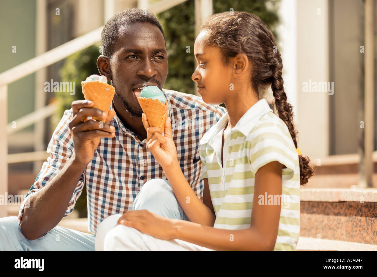 Thoughtful young man enjoying taste of ice-cream Stock Photo
