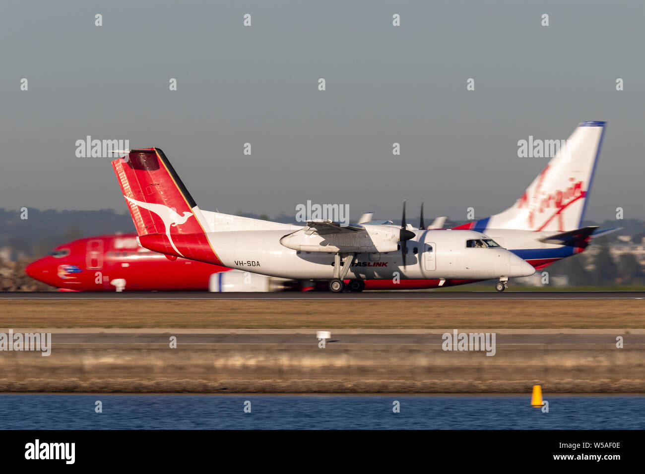 QantasLink de Havilland Canada Dash 8 twin engine turboprop regional airliner aircraft taking off from Sydney Air Stock Photo