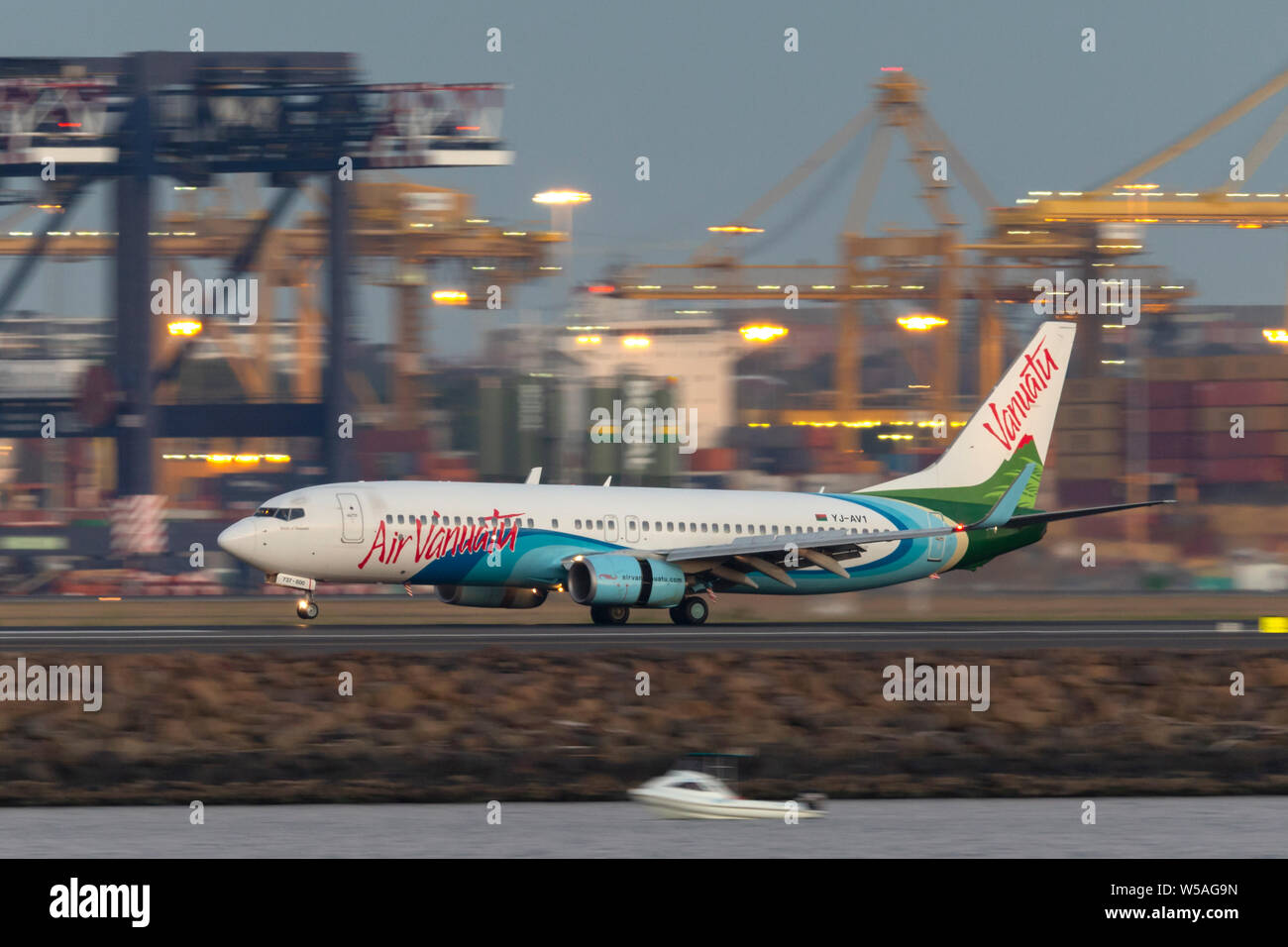 Air Vanuatu Boeing 737 airliner landing at Sydney Airport after sunset. Stock Photo