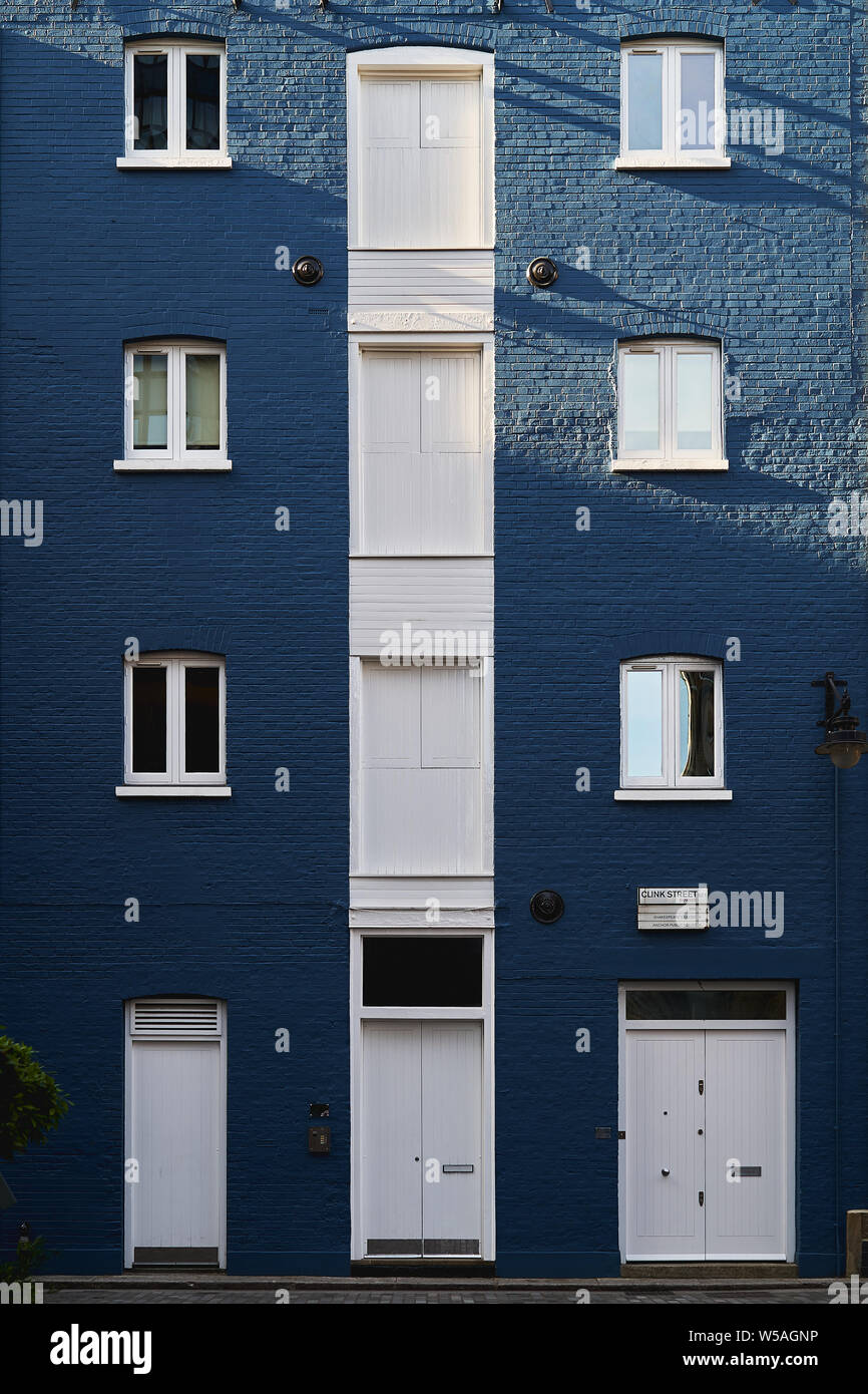 London, UK - July, 2019. Façade of a blue painted masonry residential building with white door and windows in Clink Street, near London Bridge. Stock Photo