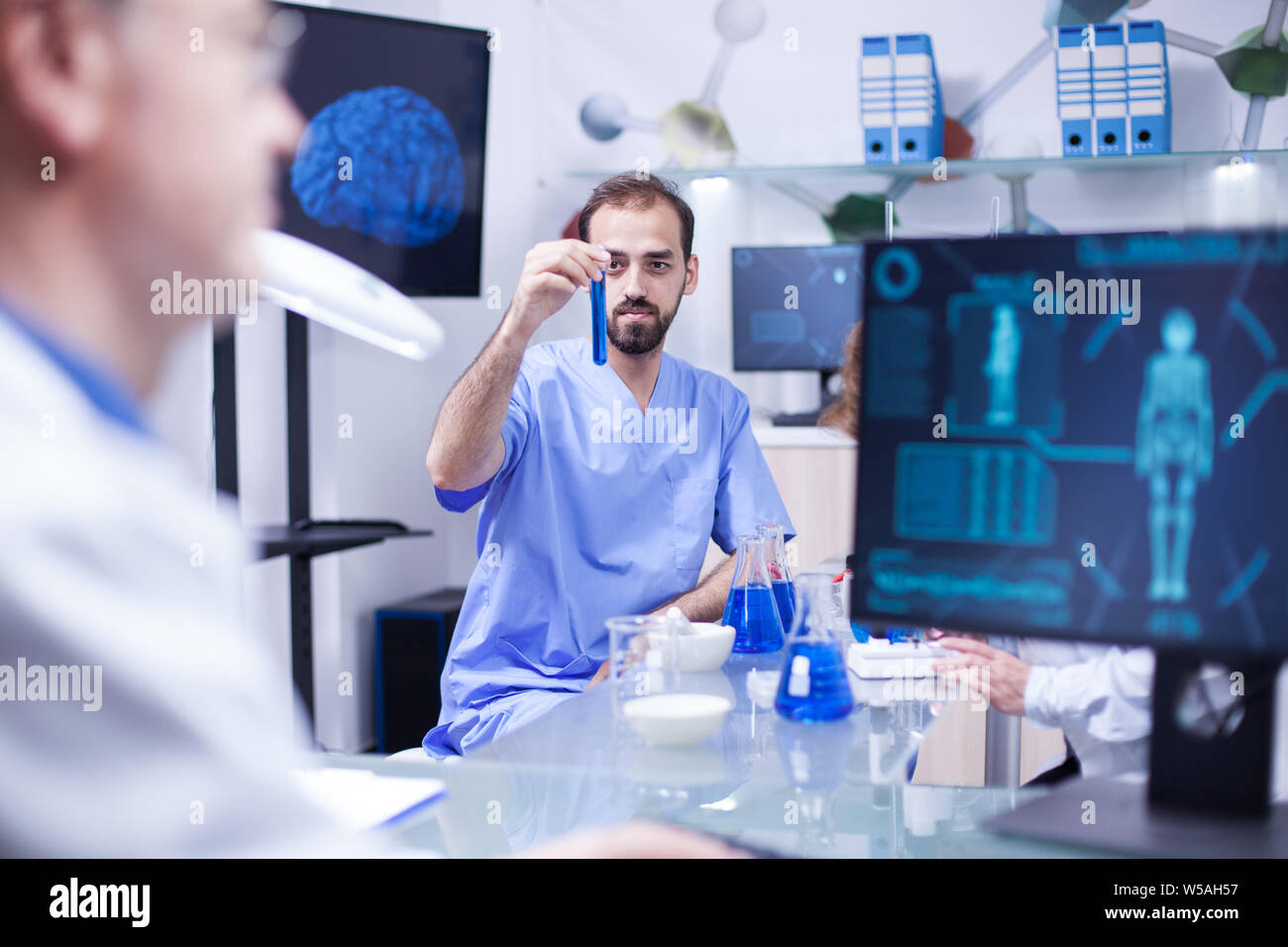 Young scientist engineer working with test tubs in a laboratory. Scientist doing experiments for pharmaceutical development. Stock Photo