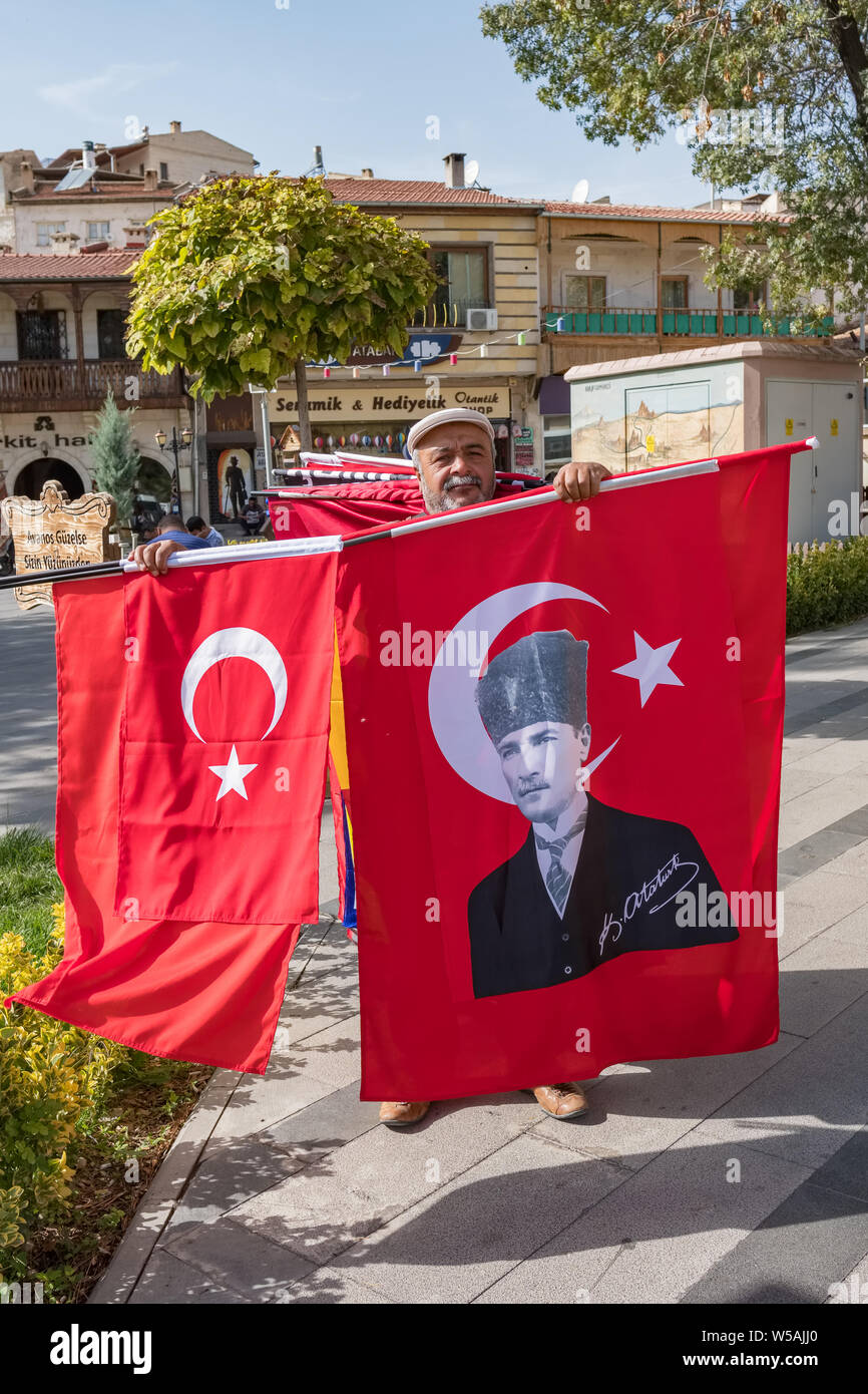Antalya, Turkey - October 19, 2018: Unidentified man sells turkish national flags and flags with portrait of Ataturk, founder of Turkish Republic, on Stock Photo