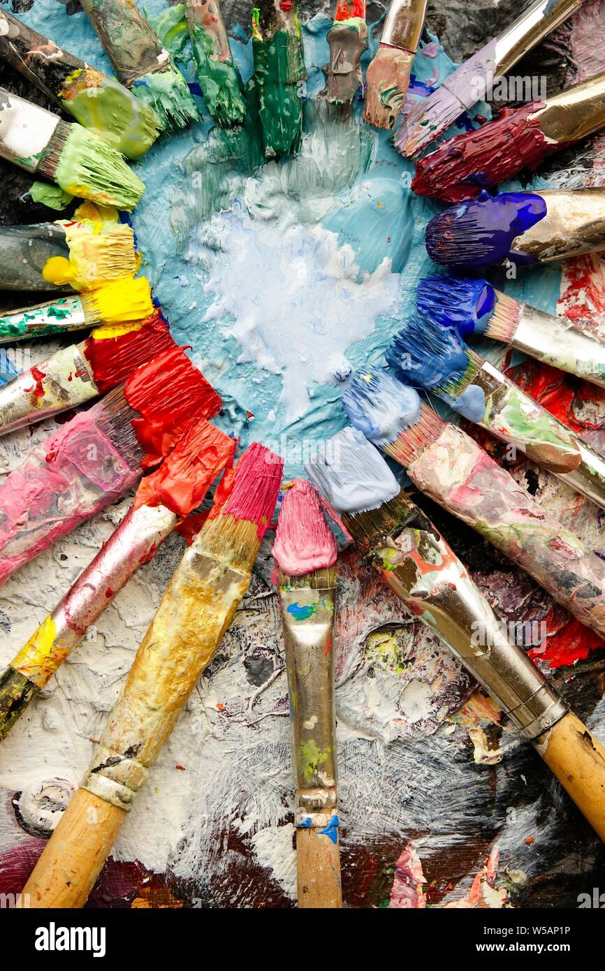 Artist paint brushes on wooden palette. Texture mixed oil paints in  different colors. Instruments and tools for creative leisure. Painting  hobby backg Stock Photo - Alamy