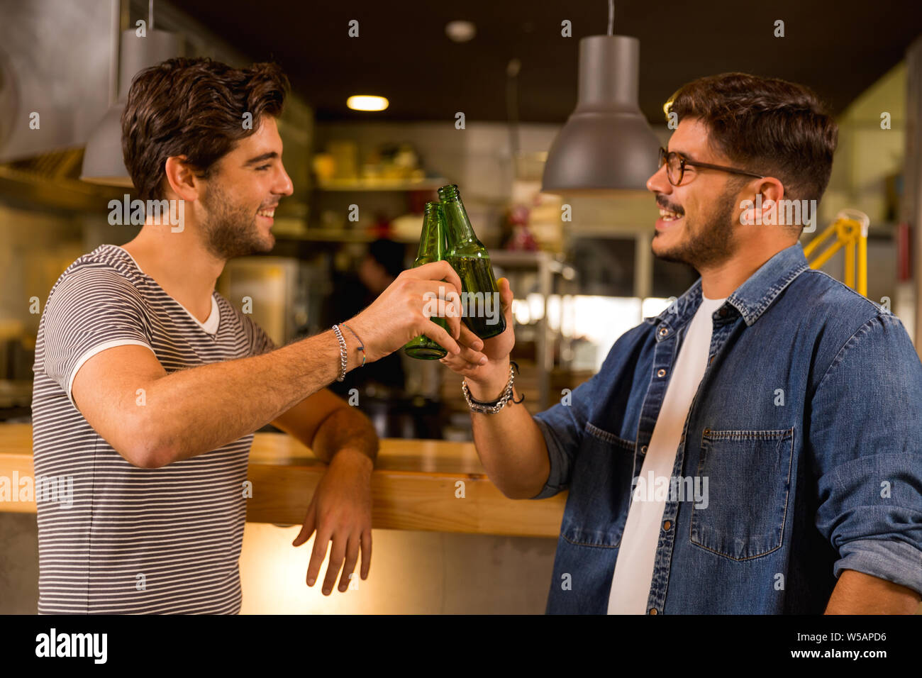 Two friends having a drink at the pub and making a toast Stock Photo