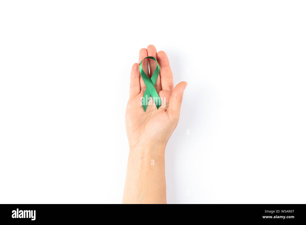 Female hand with green awareness ribbon isolated on white background ...