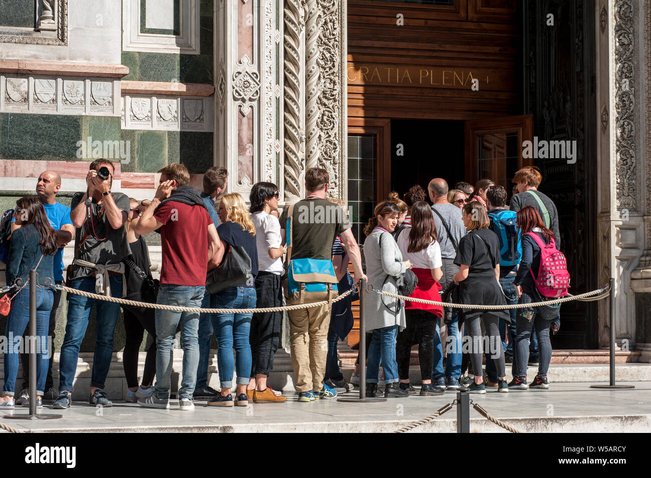 Florence, Italy - April 7, 2018: Tourists queue waiting at the entrance of Santa Maria del Fiore Cathedral, in Florence. Stock Photo