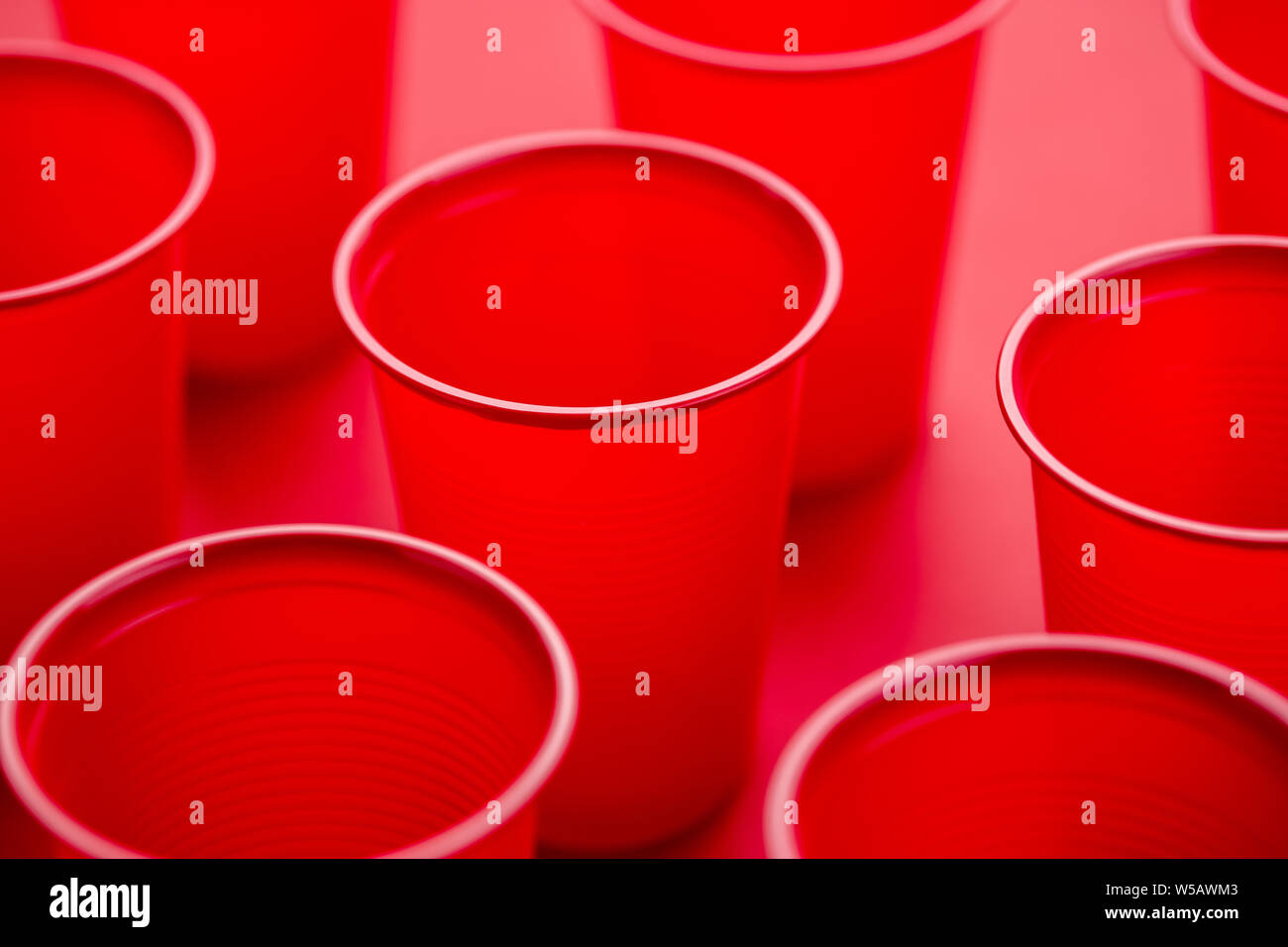 Pattern of drinking plastic disposable glasses on a red background ...