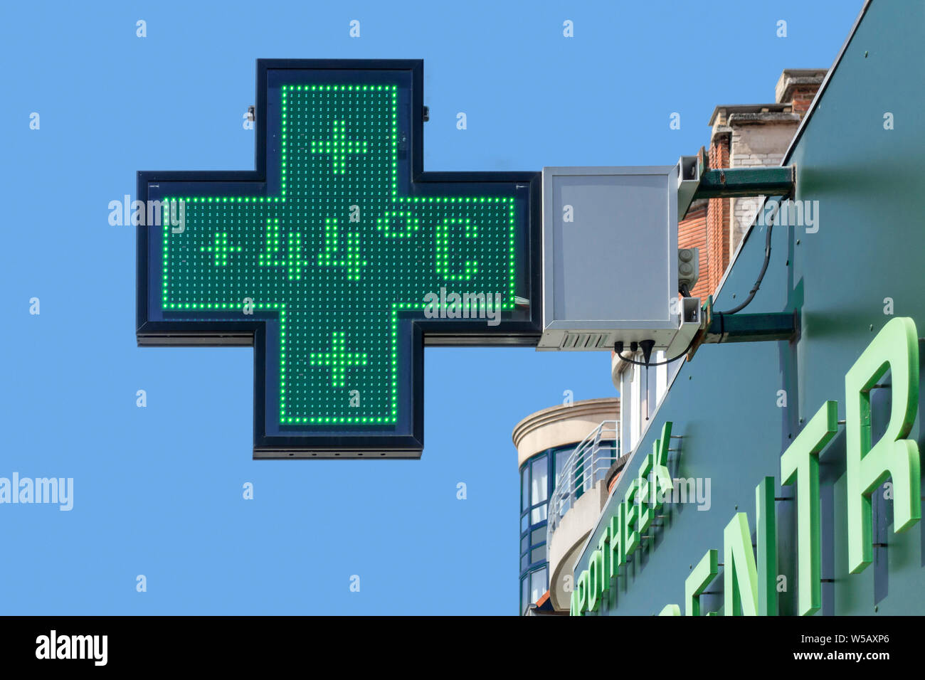 Thermometer in green pharmacy screen sign displays extremely hot temperature of 44 degrees Celsius / 44°C / 44 °C during summer heatwave / heat wave Stock Photo