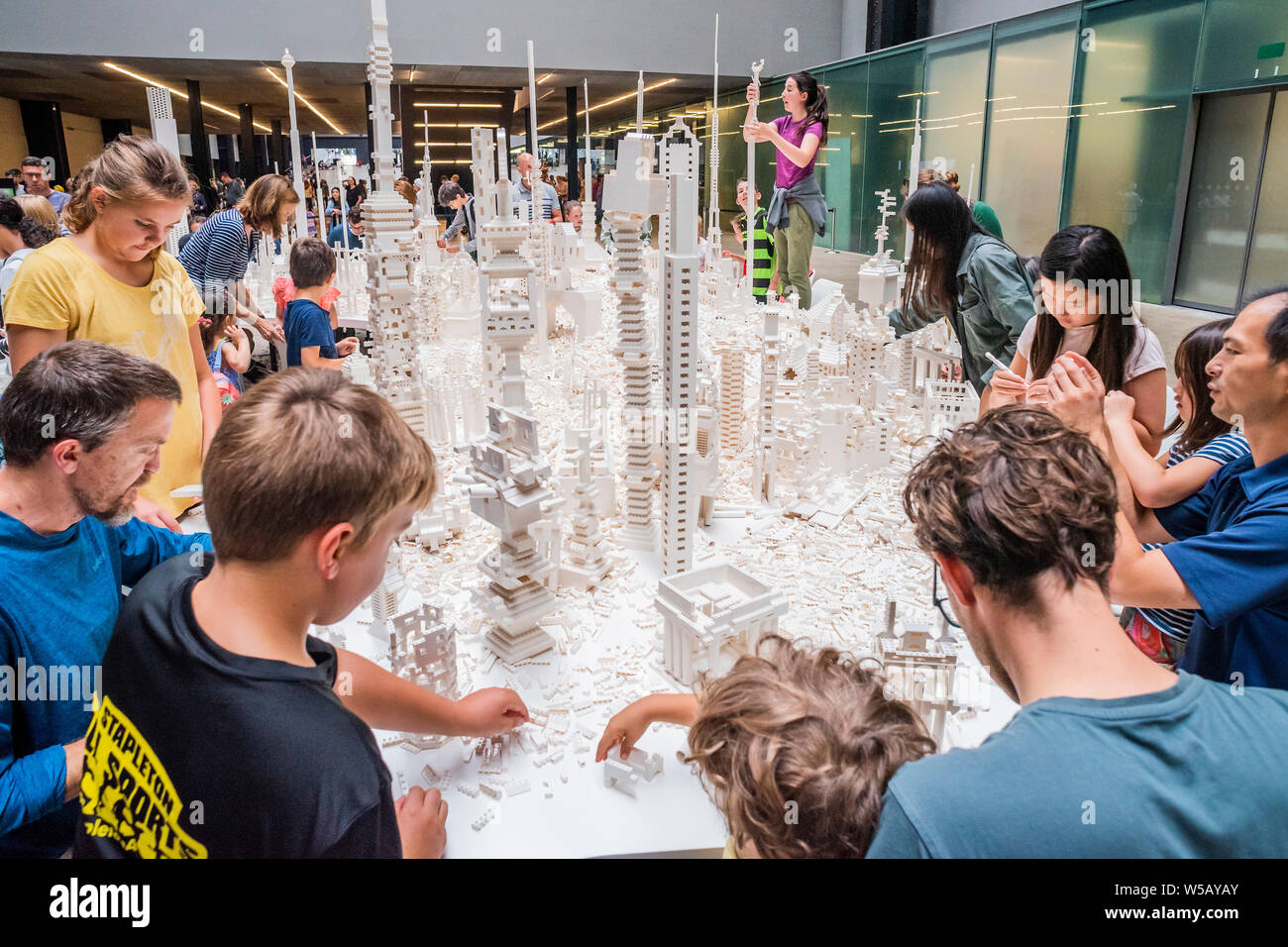 Tate Modern, Southbank, London, 27 Jul 2019 - Olafur Eliasson's The cubic structural evolution project 2004. The work comes to the UK for the first time to coincide with the artist's new exhibition, In real life, at Tate Modern; an unmissable survey spanning over 30 years of Eliasson's career. Taking over the Turbine Hall for three weeks, this free interactive artwork invites visitors to unleash their architectural vision for a future city using over one tonne of white Lego bricks. Credit: Guy Bell/Alamy Live News Stock Photo