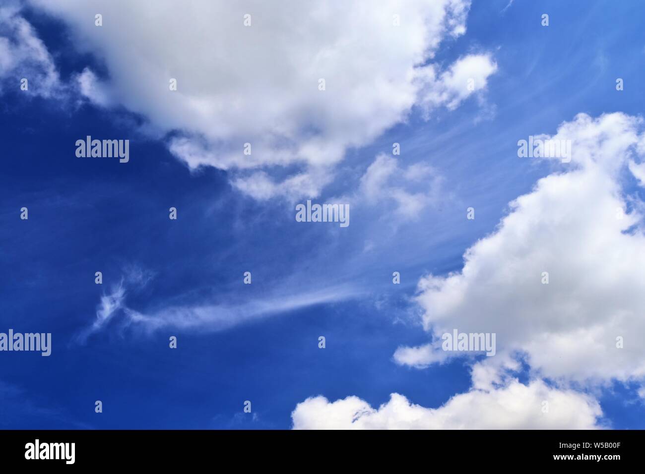 Beautiful white fluffy clouds on a deep blue summer sky Stock Photo - Alamy