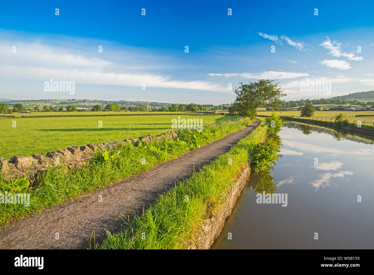 Landscape view of English rural countryside scenery on British waterway canal with blue sky Stock Photo