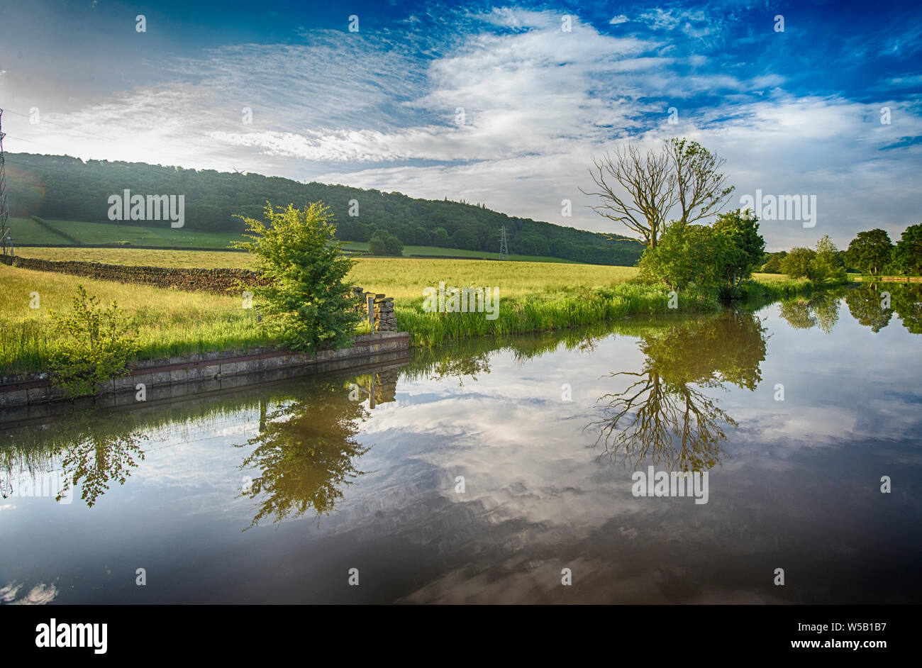 Landscape view of English rural countryside scenery on British waterway canal during cloudy day Stock Photo
