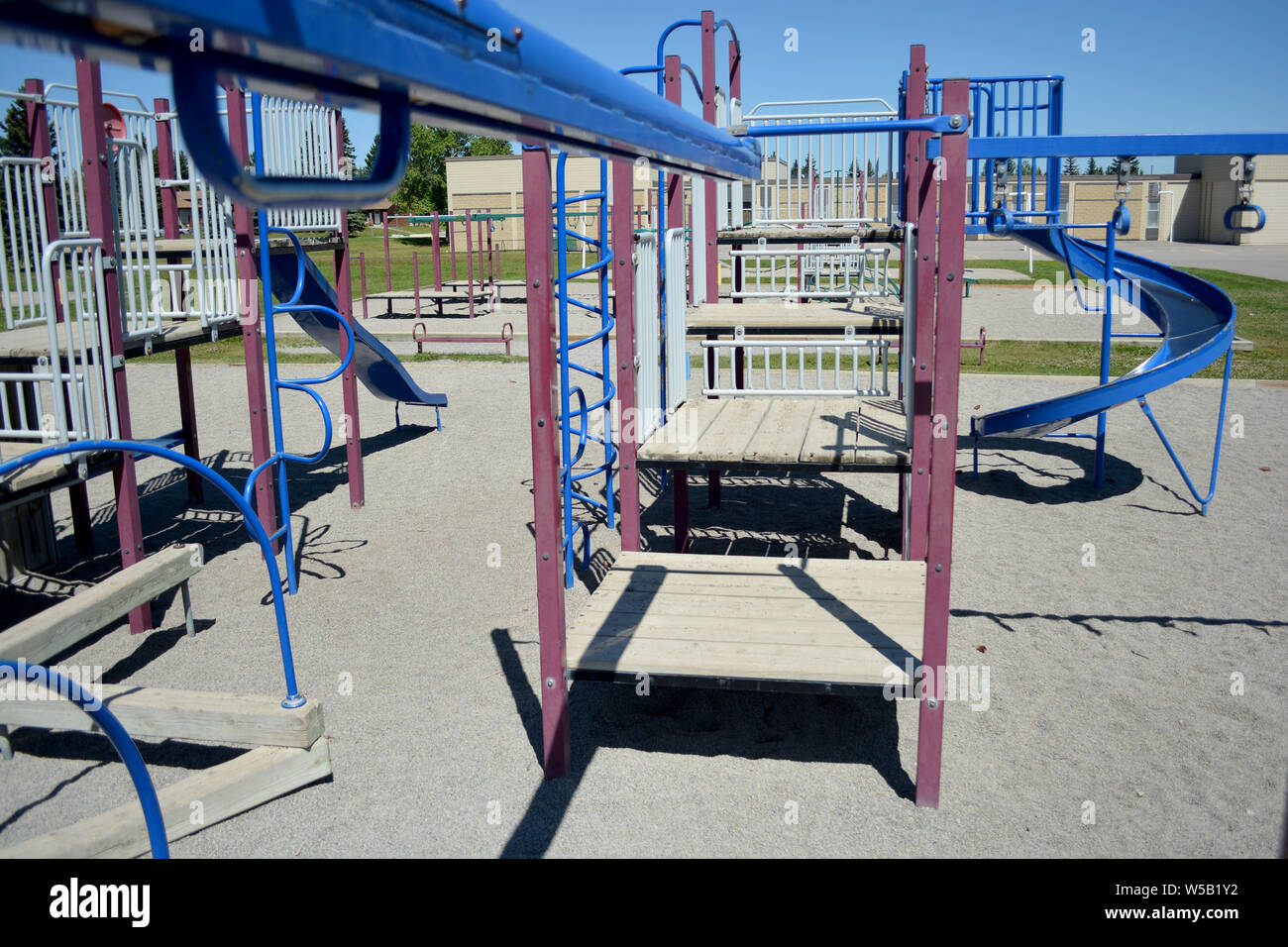 Colourful playground equipment in school yard on sunny day. Stock Photo