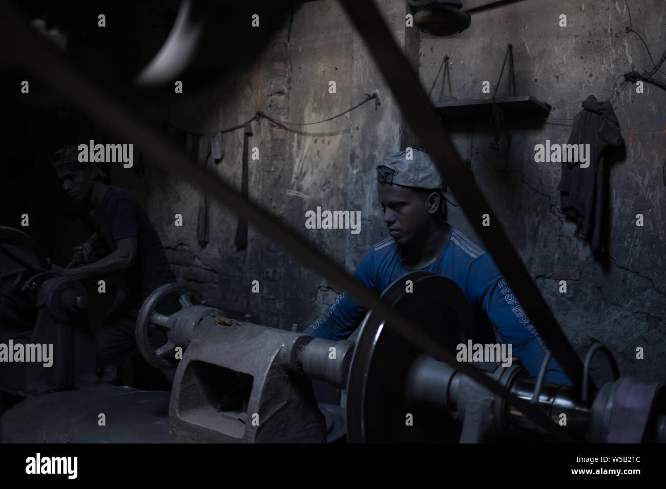 Labors working on a sliver cooking pot factory in Dhaka, Bangladesh