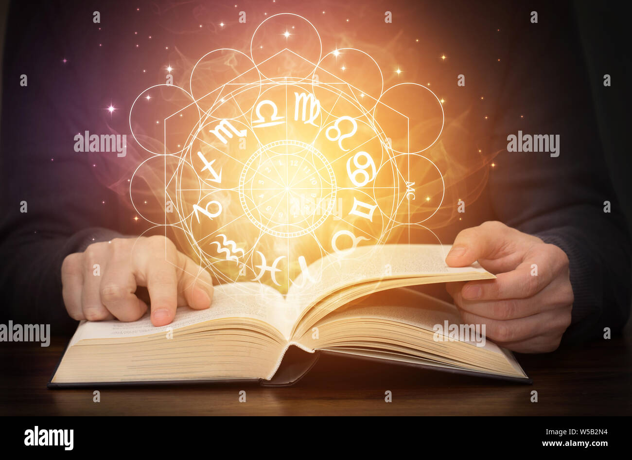 astrology book with zodiac signs and shining light Stock Photo