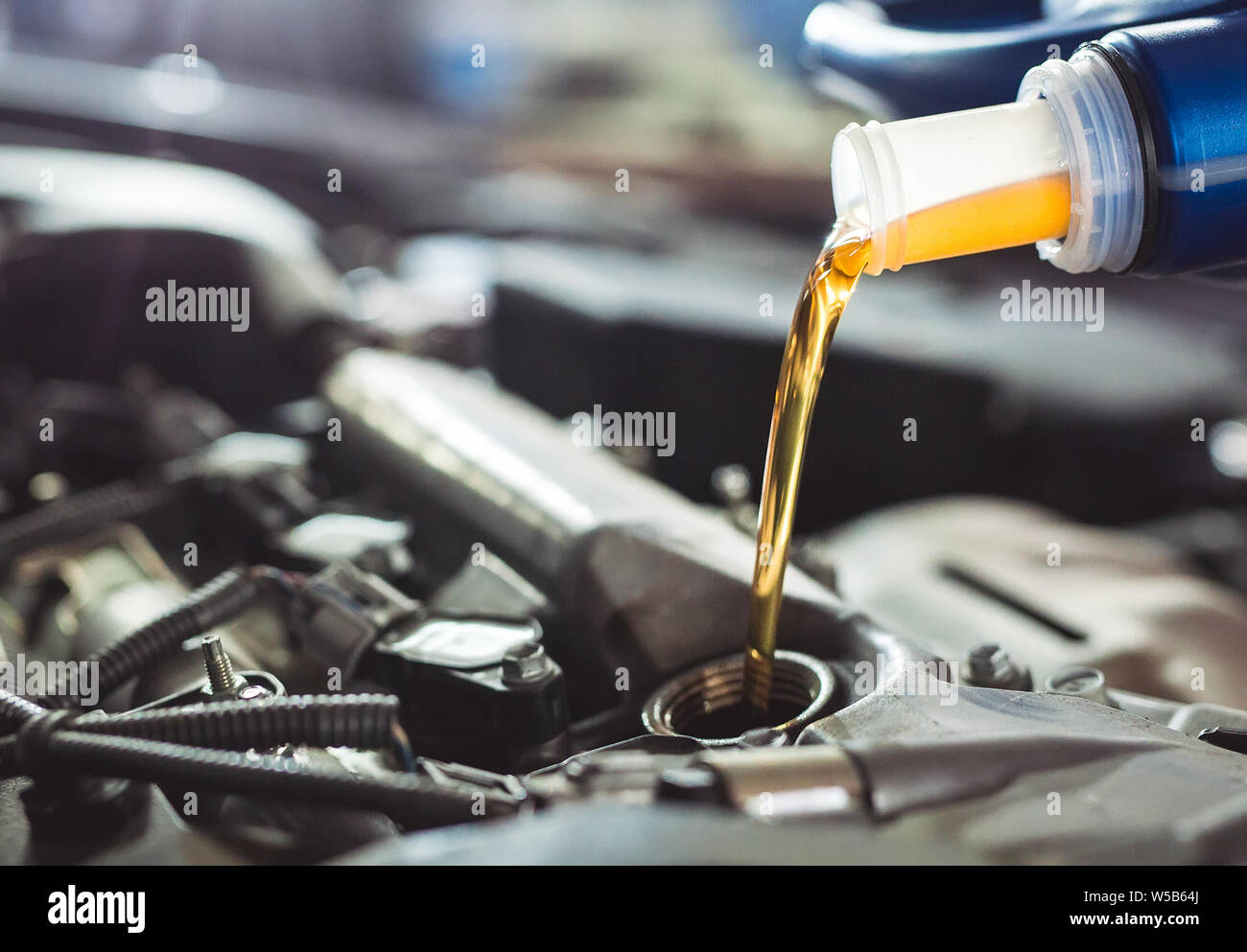 Motor oil pouring to car engine. Repair service Stock Photo - Alamy