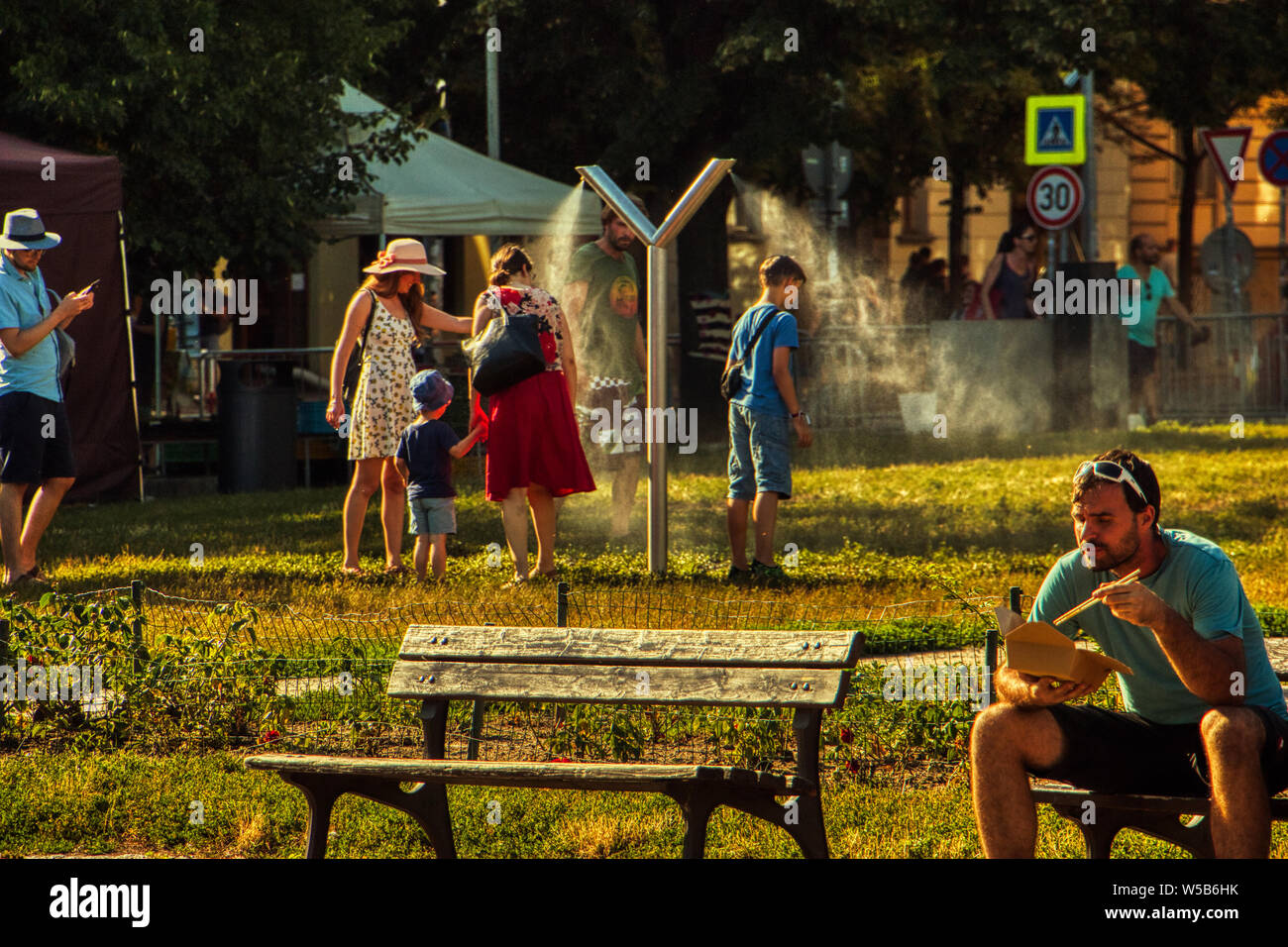 Prague, July 27 2019. People cools down sun in public mist machina at Park under Europe heat wave Stock Photo