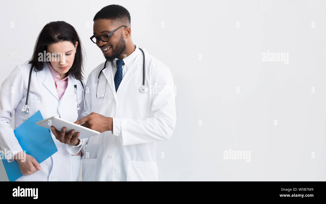 Two doctors in white coats discussing diagnosis Stock Photo