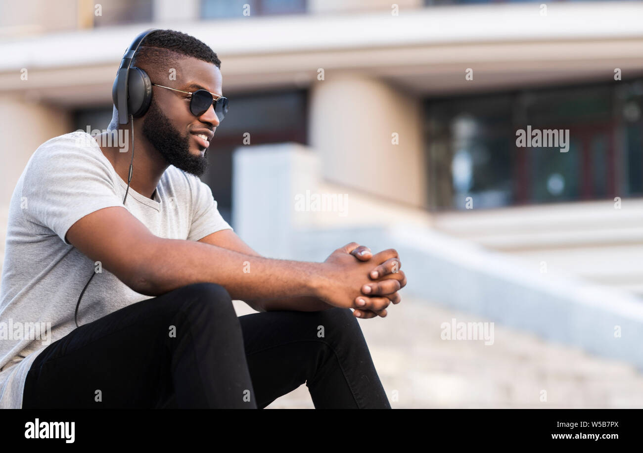 African guy in headphones listening to music having good mood Stock Photo