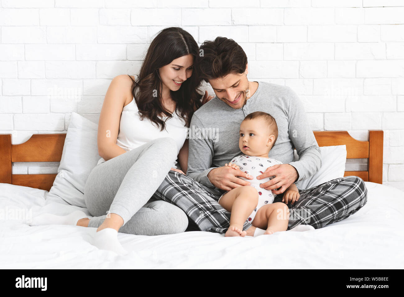 Cheerful millennial parents enjoying weekend with baby son Stock Photo