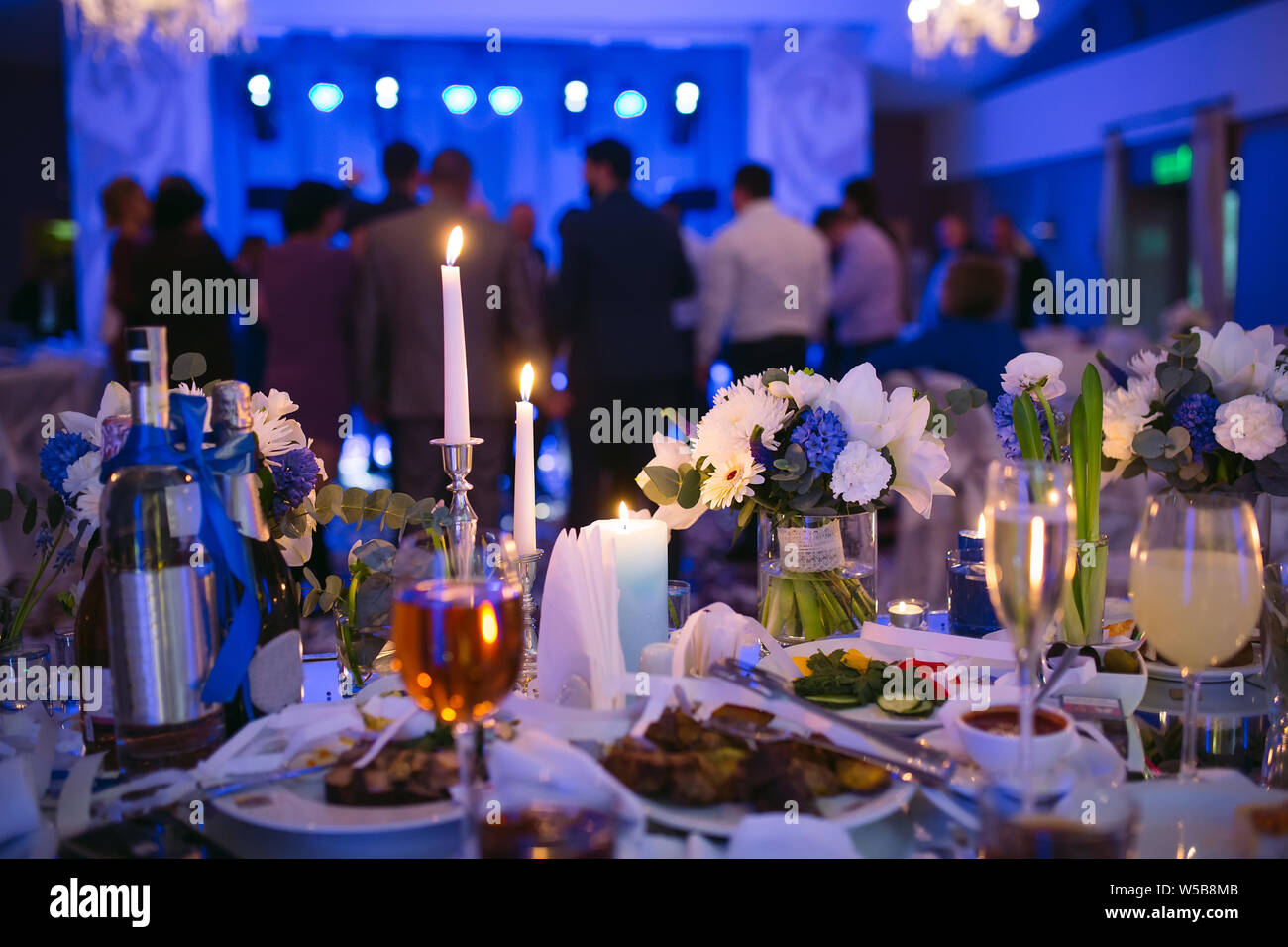 Wedding table settings in the restaurant. People dancing in the