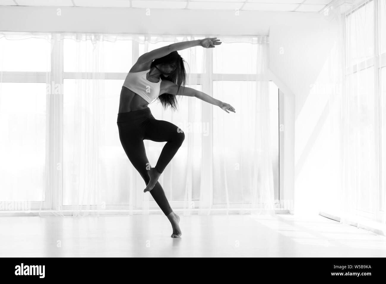 Young Woman Training Contemp In Modern Dance Studio. Black And W Stock Photo