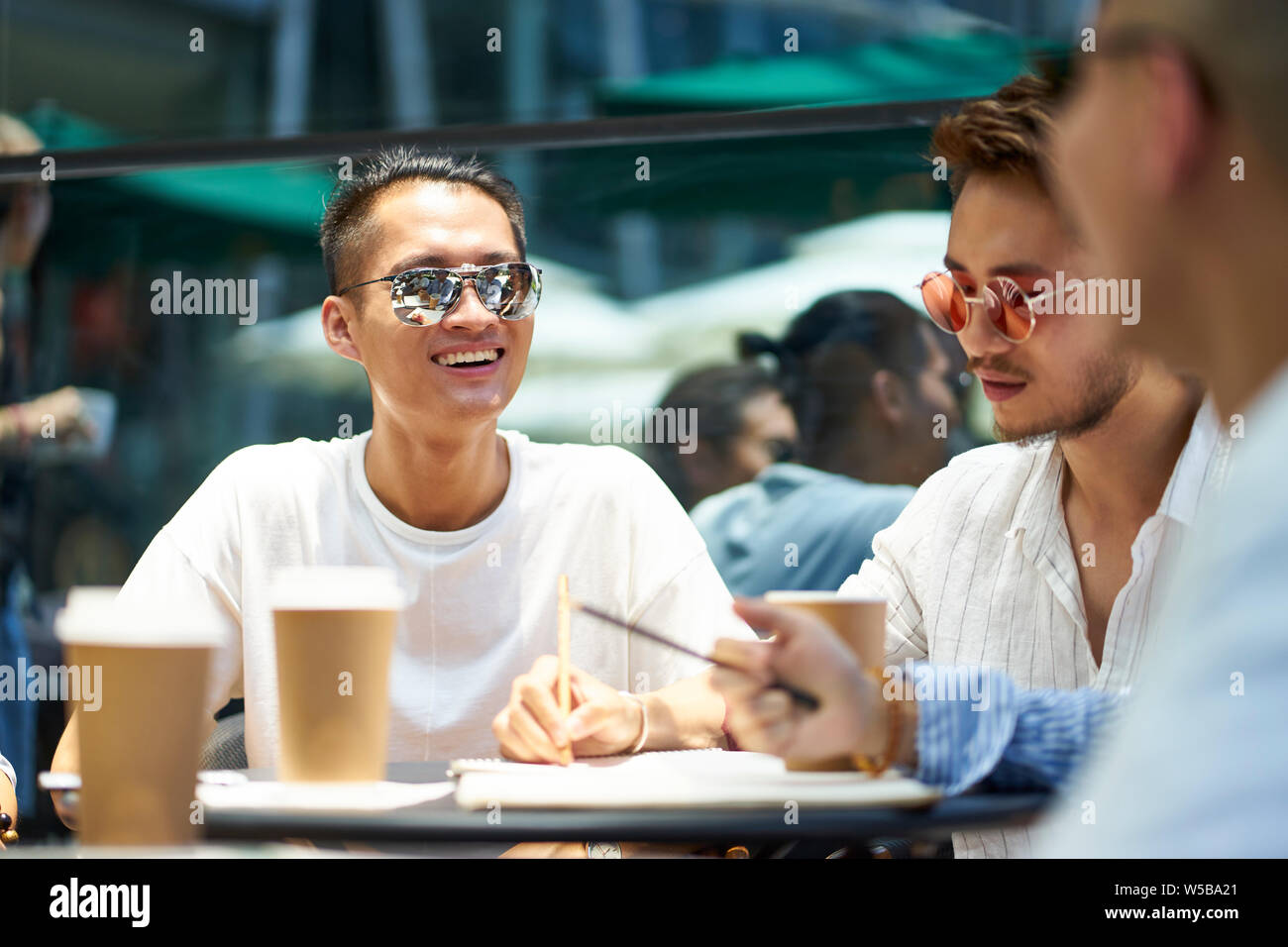 young asian people man and woman relaxing chatting in outdoor coffee shop Stock Photo