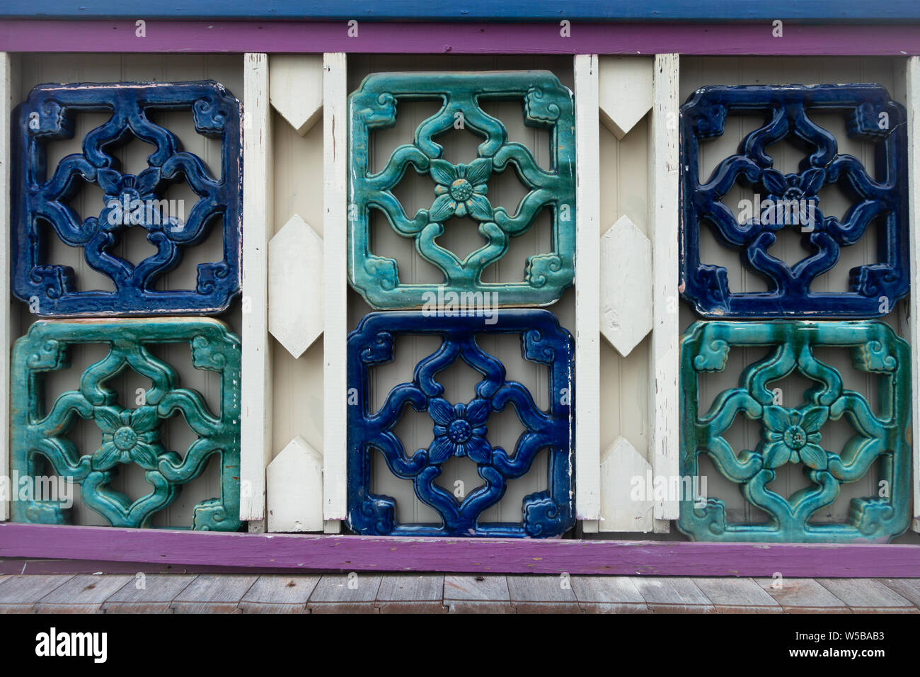 Colorful decorative wall with ornate ceramic tile panels in teal and blue featuring traditional floral and geometric motifs Stock Photo