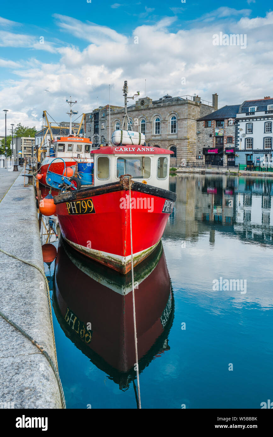 Little red fishing boat at Sutton Harbour, formerly known as Sutton Pool, original port of City of Plymouth at historic Barbican district. Devon. UK. Stock Photo