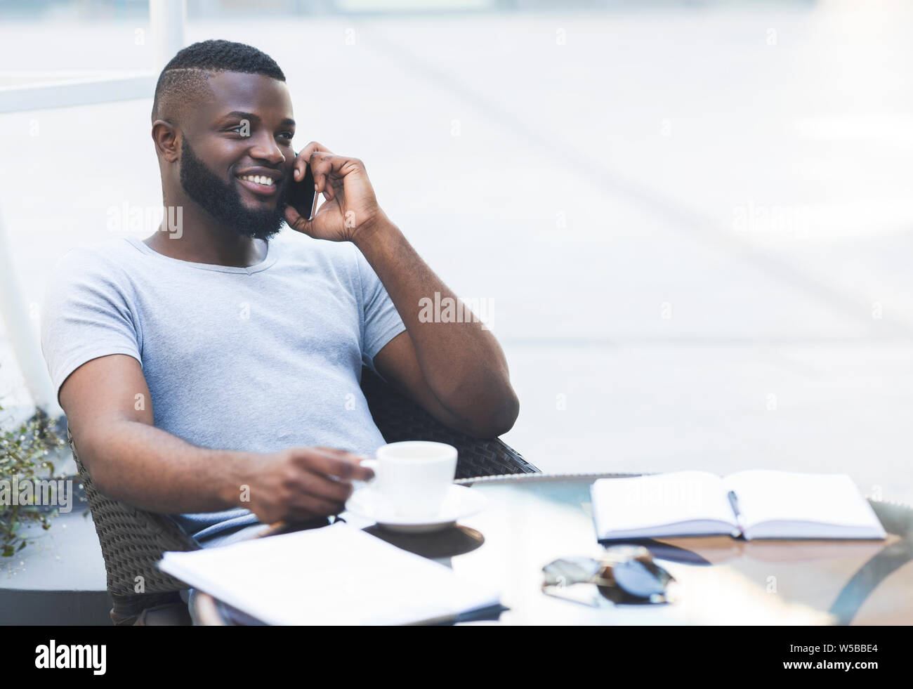 Young african guy relaxing during lunch time, drinking coffee Stock Photo