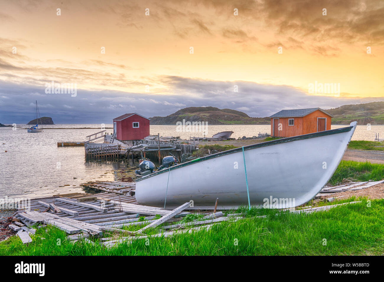 Boats and sheds in coastal fishing village during sunset in Newfoundland, Canada Stock Photo