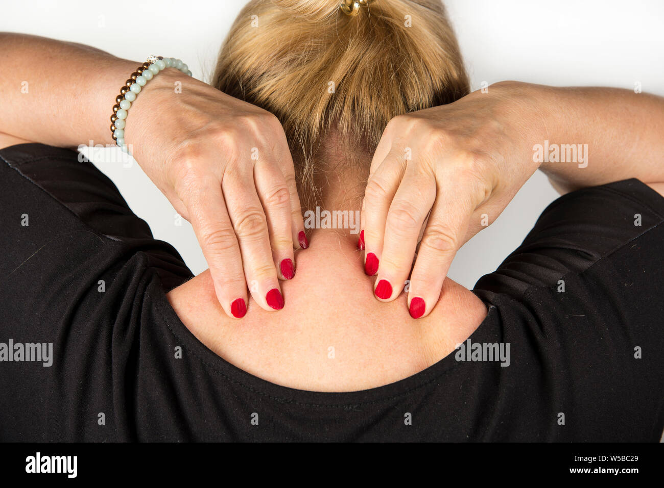 Mature women with neck pain. Self massage concept Stock Photo - Alamy