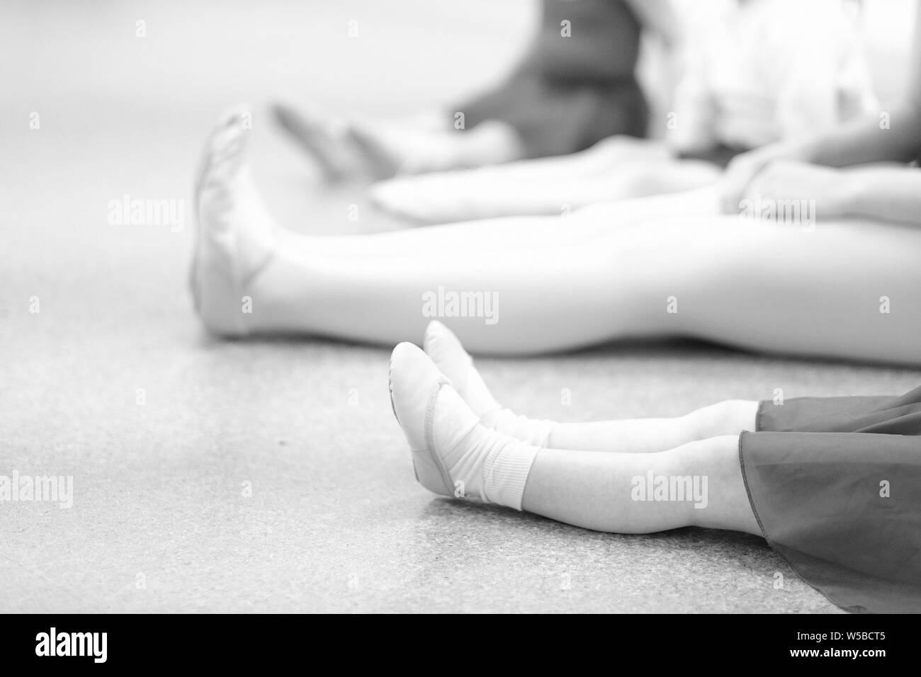 Girls with a choreographer sit on the floor in a dance class Stock Photo