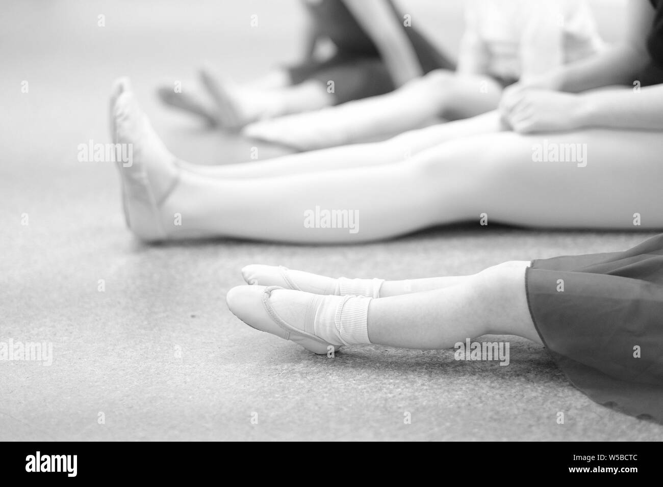 Girls with a choreographer sit on the floor in a dance class Stock Photo