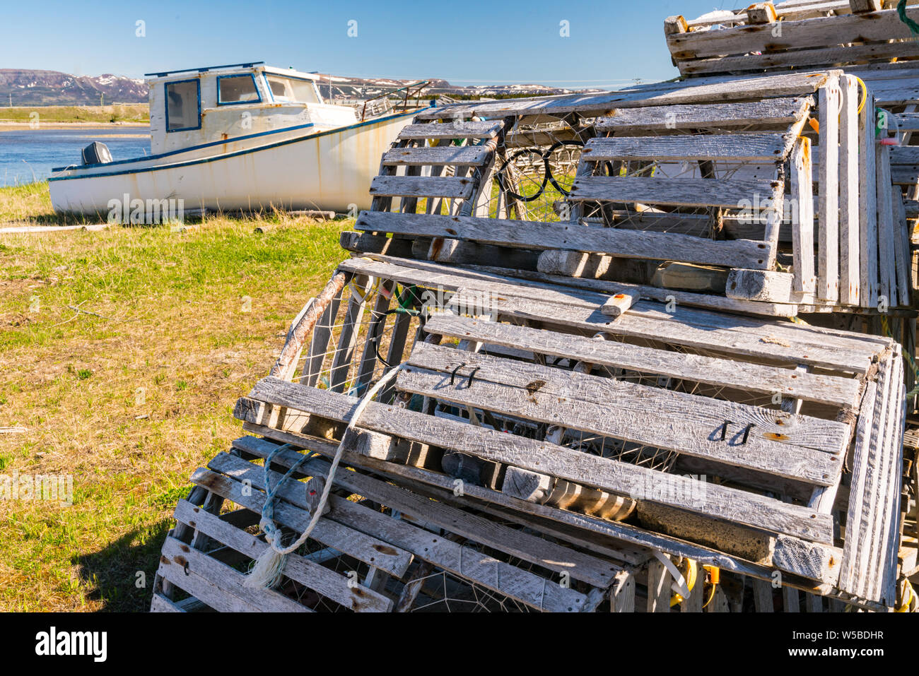 Old wooden lobster traps and fishing boats in Newfoundland, Canada Stock Photo