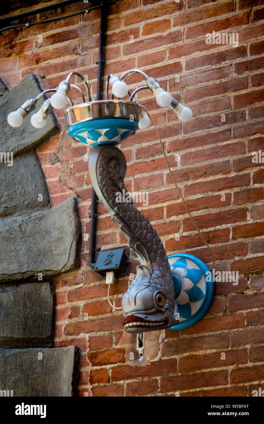 Street light fixture representing the Onda or Wave and dolphin contrade neighborhood in Siena, Italy Stock Photo