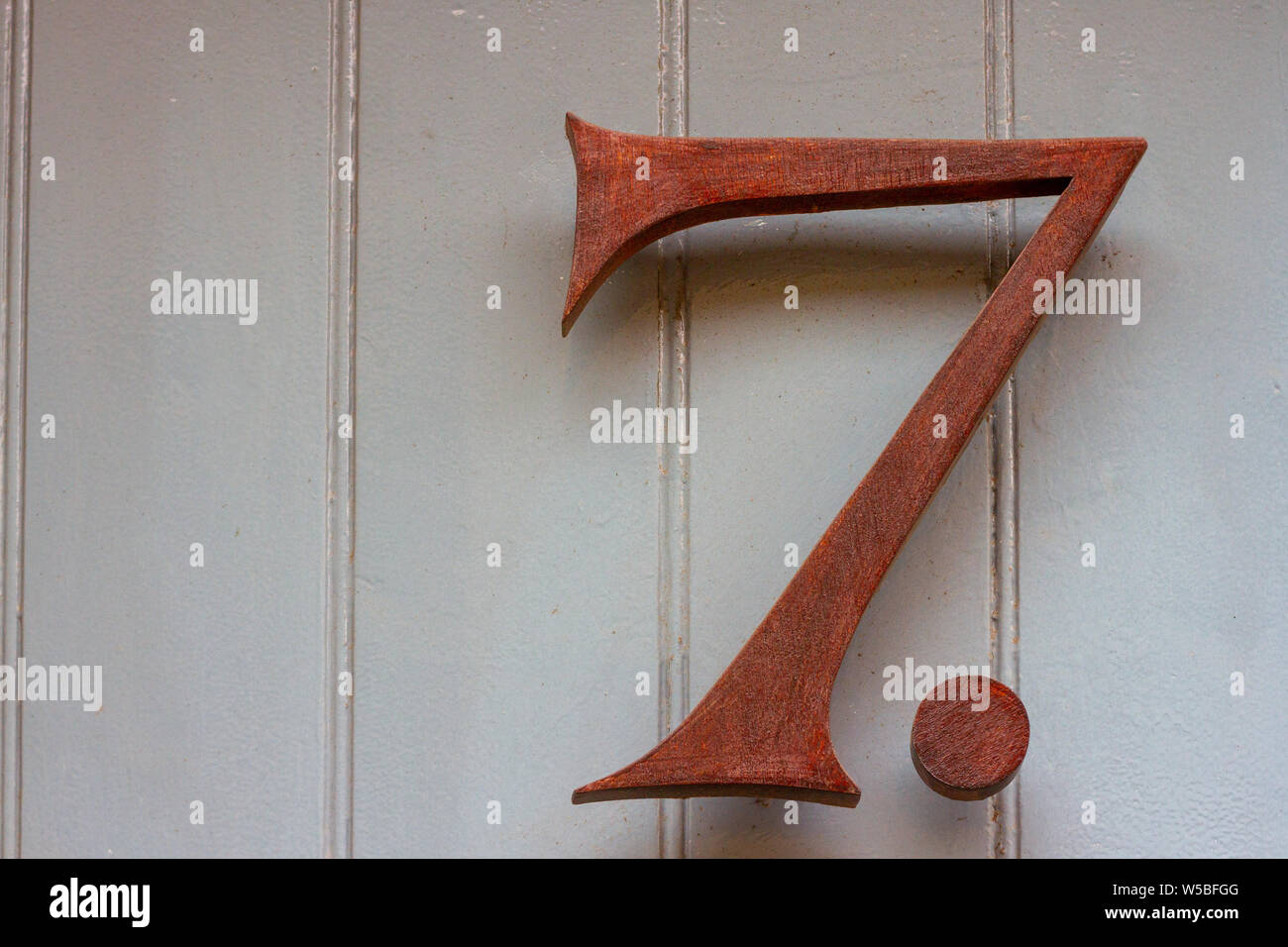 House number 7 with a punctuation mark after the metal seven Stock Photo