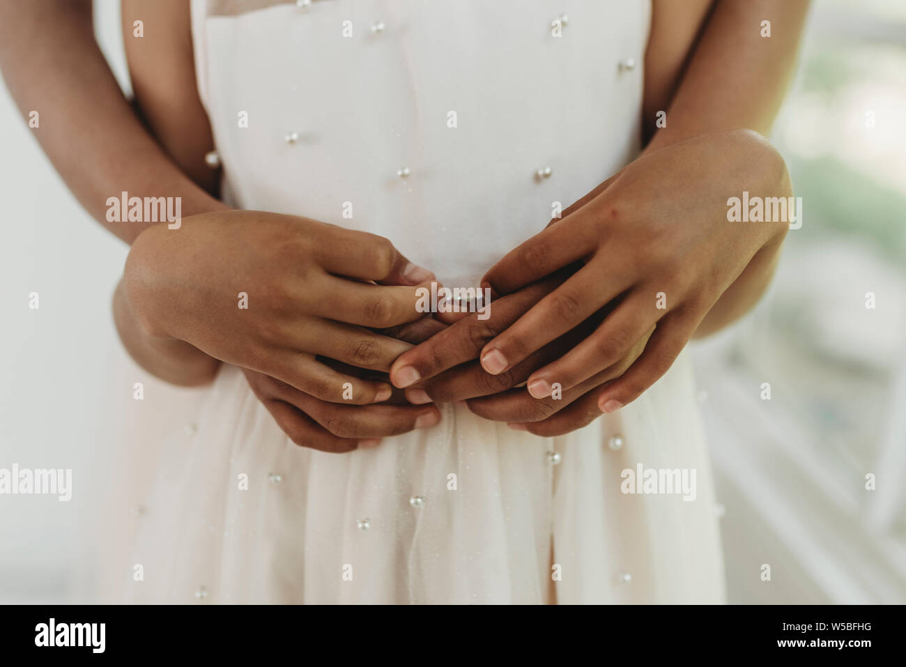 Close up of sisters' hands intertwined in studio Stock Photo
