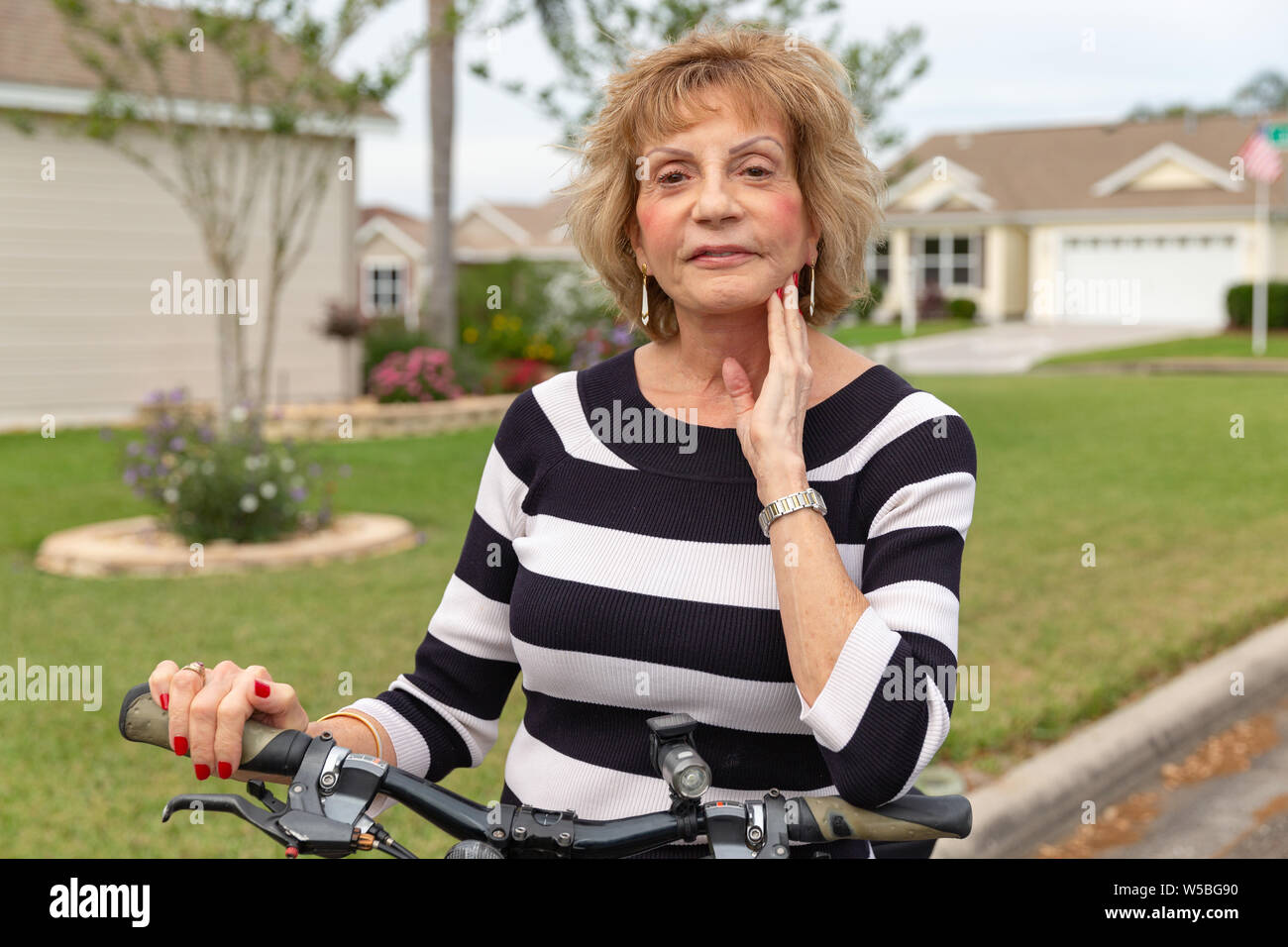Mature woman in her seventies enjoying a day outside on her bike. Stock Photo
